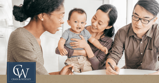 Happy family sitting at table talking with another person.
