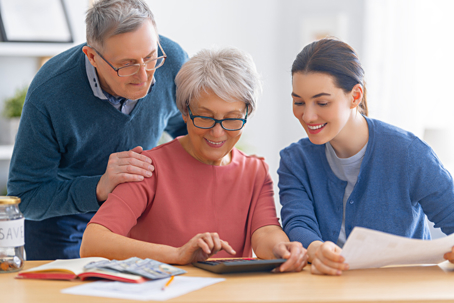 woman with elderly parents budgeting at home