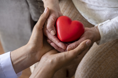 closeup of hands holding a heart figurine