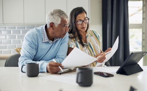 elderly couple looking at documents