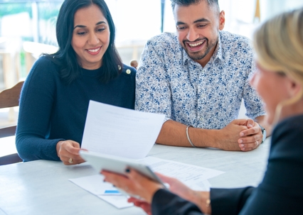 happy couple discussing documents with lawyer