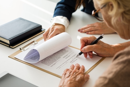 older woman signing legal documents